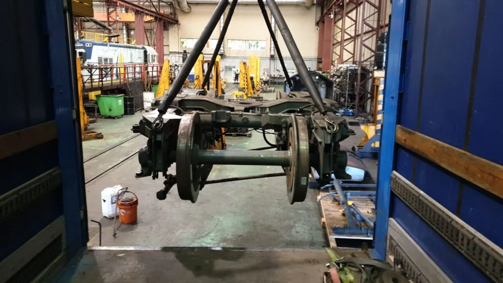 Chasis de tren suspendido en taller de mantenimiento industrial.
